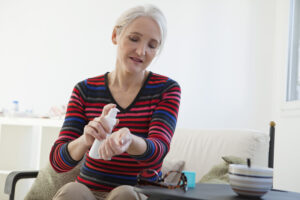A menopausal bioidentical hormone replacement therapy patient prepare to dispense her hormones topically onto her wrist. 